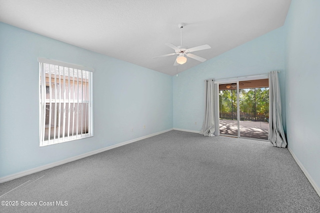 carpeted spare room featuring vaulted ceiling and ceiling fan