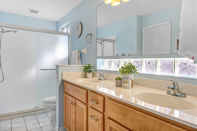 bathroom with tile patterned flooring, vanity, a shower with door, and toilet