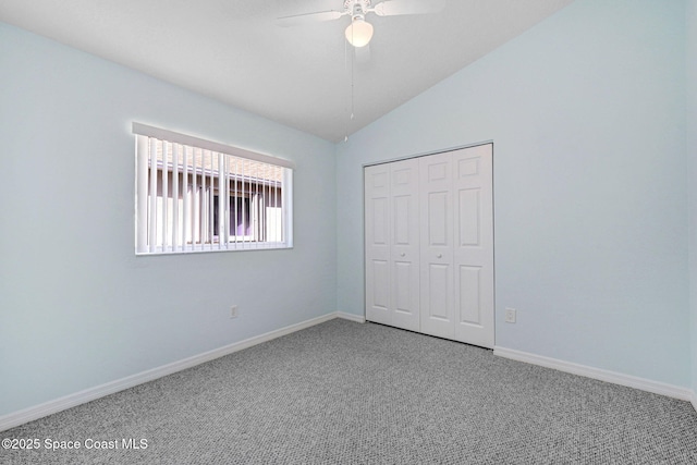 unfurnished bedroom featuring carpet, lofted ceiling, ceiling fan, and a closet