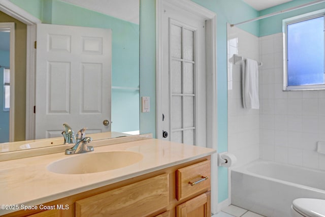 full bathroom with tile patterned floors, vanity, toilet, and tiled shower / bath combo