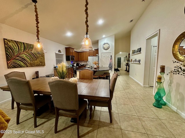 dining room featuring light tile patterned floors and high vaulted ceiling