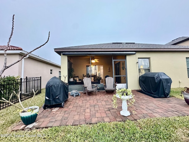 rear view of property with ceiling fan and a patio area