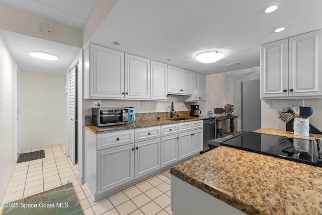 kitchen featuring sink, light tile patterned floors, and white cabinets