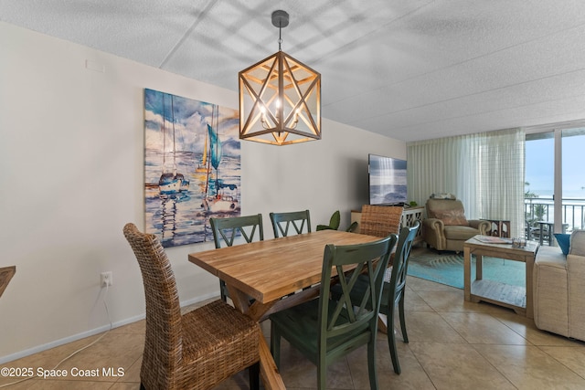 dining room featuring expansive windows, light tile patterned floors, and a notable chandelier