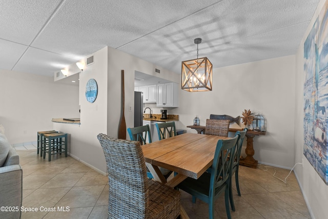 tiled dining space with an inviting chandelier and sink