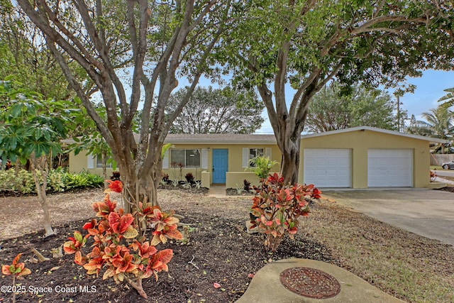 single story home featuring a garage, concrete driveway, and stucco siding