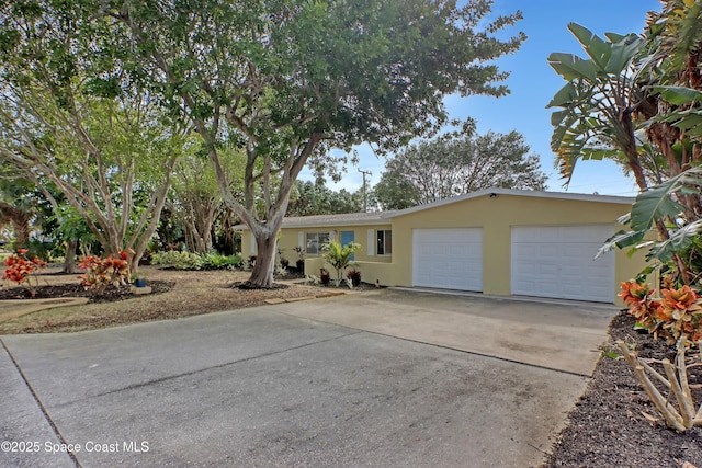 single story home with driveway, an attached garage, and stucco siding