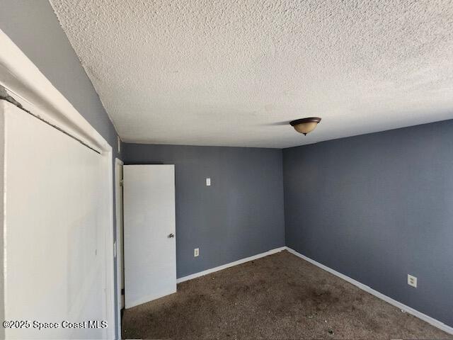 unfurnished bedroom with carpet floors and a textured ceiling