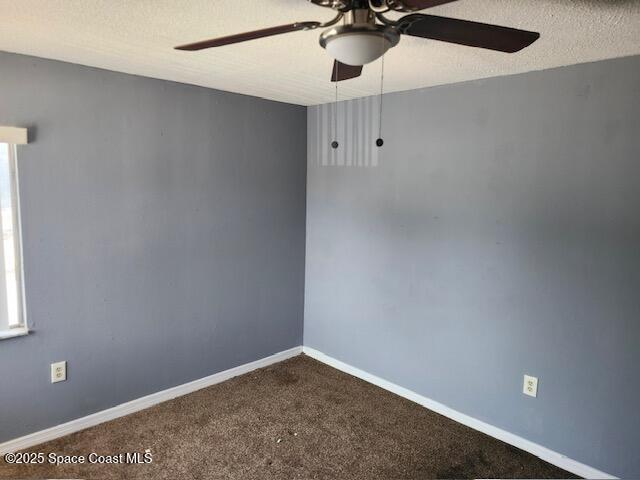 carpeted empty room with ceiling fan and a textured ceiling