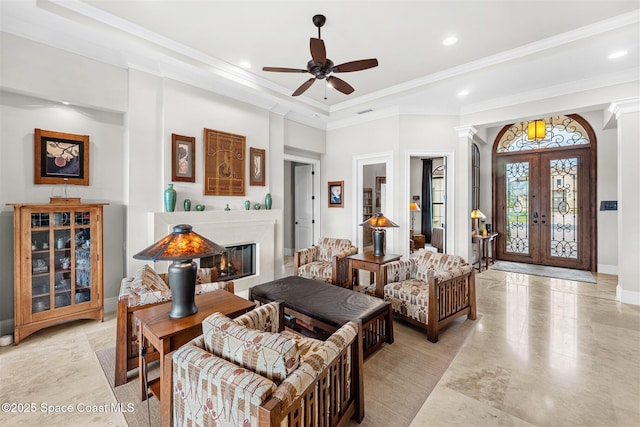 living room with crown molding, ceiling fan, french doors, and ornate columns