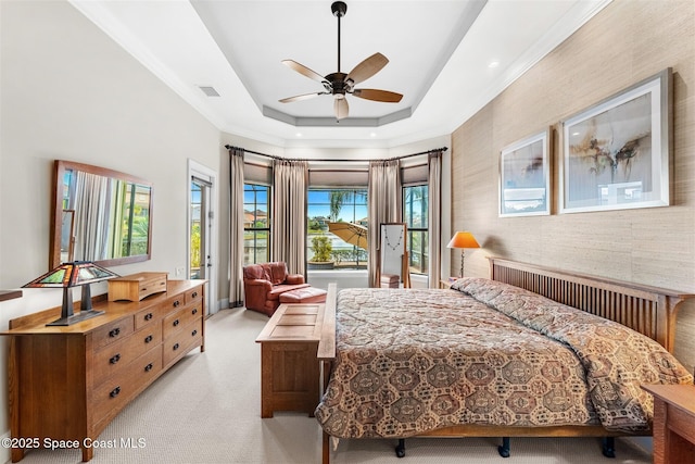 carpeted bedroom with ceiling fan, access to exterior, and a raised ceiling