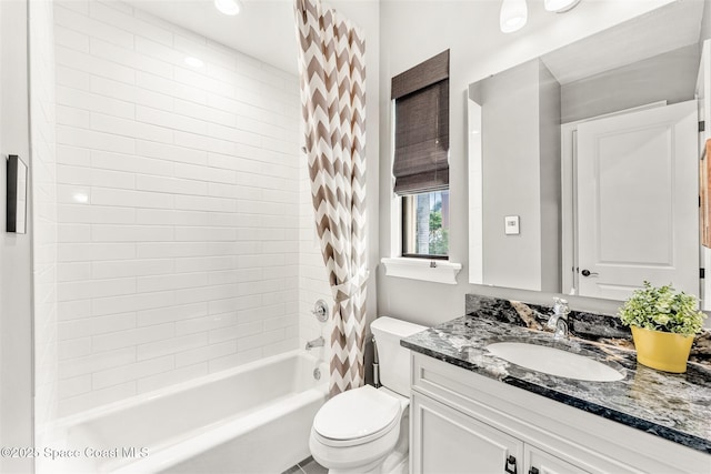 full bathroom featuring vanity, tiled shower / bath combo, and toilet