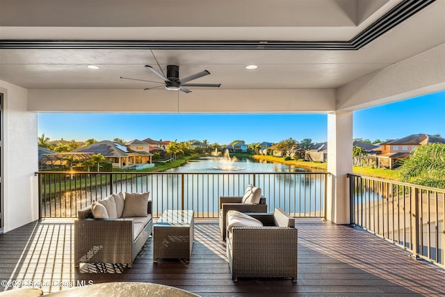 wooden terrace with a water view, an outdoor hangout area, and ceiling fan