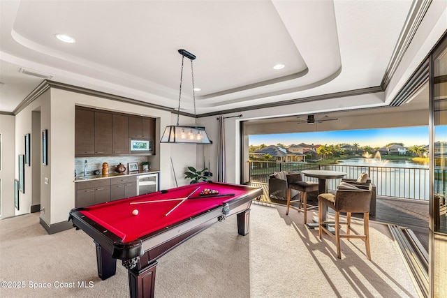 playroom with sink, ornamental molding, a raised ceiling, and a water view