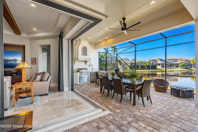 sunroom featuring a water view and ceiling fan