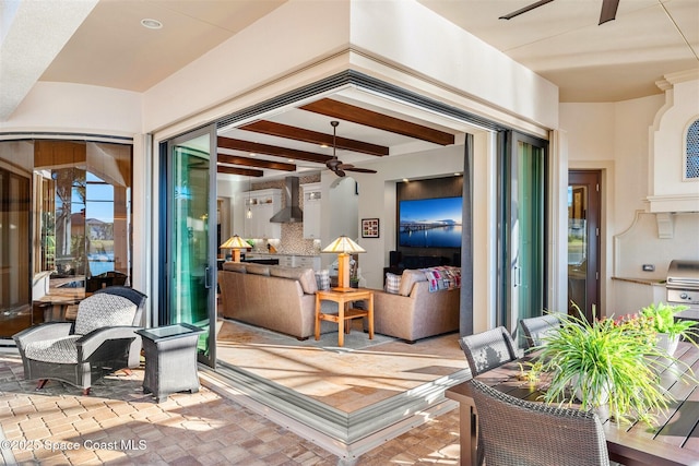 living room featuring beamed ceiling and ceiling fan