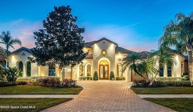 mediterranean / spanish house with a yard and french doors