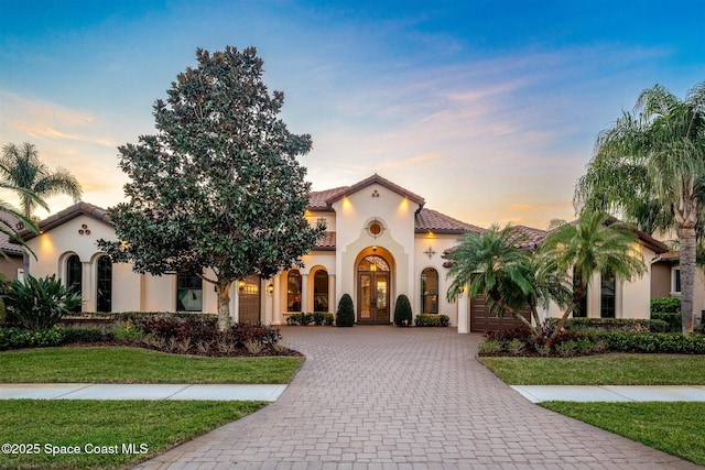 mediterranean / spanish home with a lawn