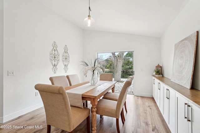 dining room featuring lofted ceiling and light wood-type flooring