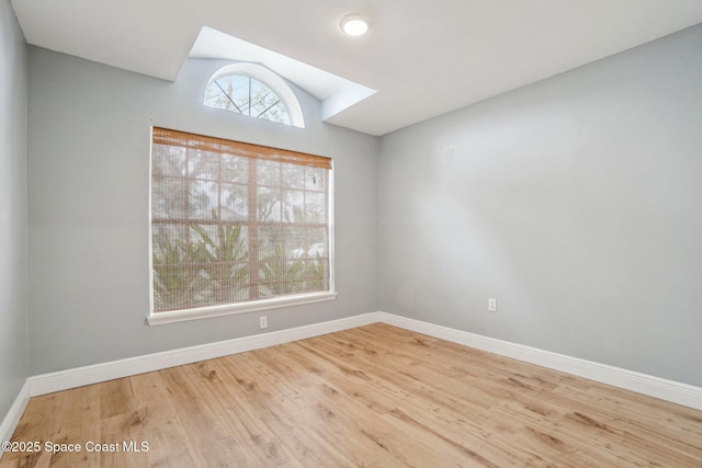 empty room featuring hardwood / wood-style flooring and lofted ceiling