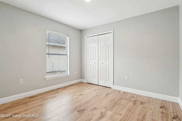 unfurnished bedroom with light hardwood / wood-style floors and a closet