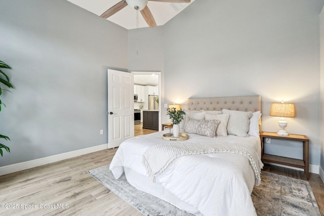 bedroom with light hardwood / wood-style flooring, high vaulted ceiling, and ceiling fan