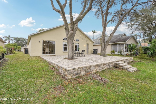 back of house featuring central AC, a patio area, and a lawn