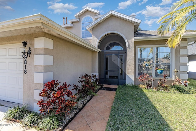 property entrance featuring a garage and a yard