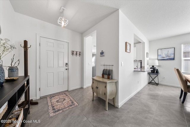 tiled entryway with a textured ceiling