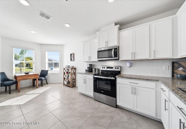 kitchen featuring white cabinetry, appliances with stainless steel finishes, and light stone counters