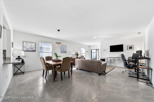 dining room with light tile patterned floors and a textured ceiling