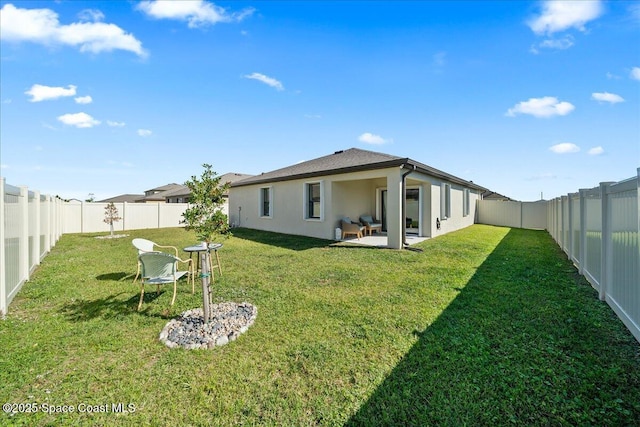 rear view of house featuring a yard and a patio