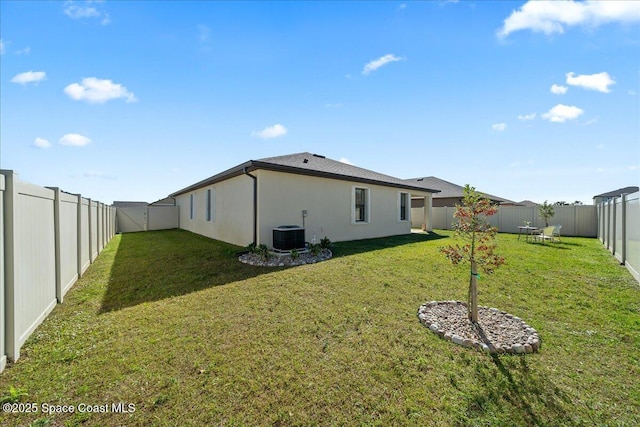 back of property with cooling unit and a yard