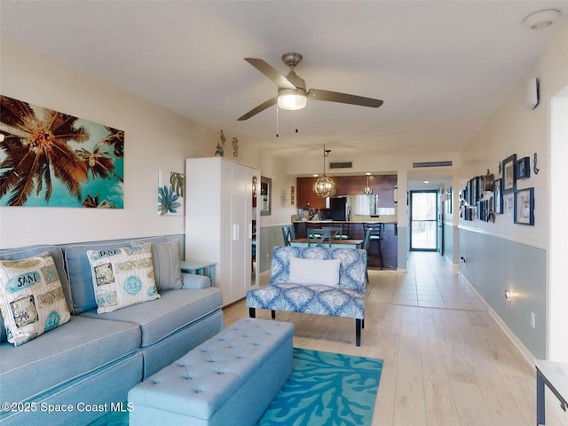 living room with ceiling fan and light wood-type flooring