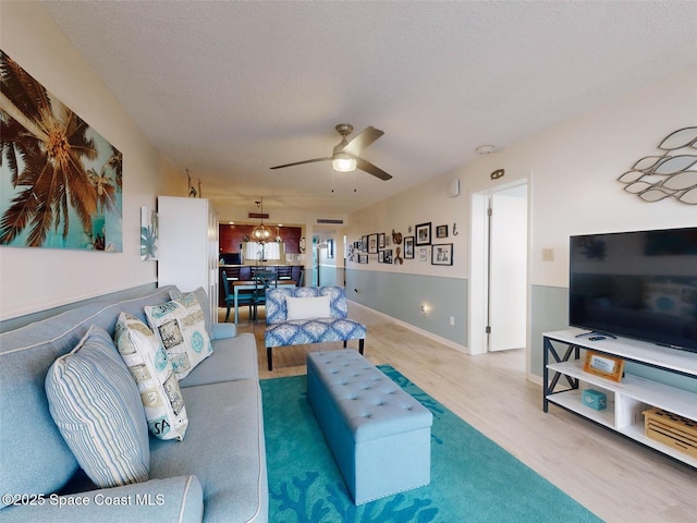 living room with ceiling fan, hardwood / wood-style floors, and a textured ceiling