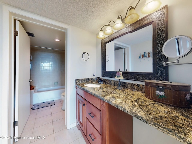 full bathroom featuring toilet, tiled shower / bath, a textured ceiling, vanity, and tile patterned flooring