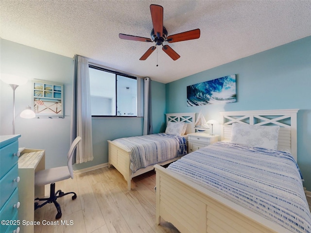 bedroom with a textured ceiling, ceiling fan, and light wood-type flooring