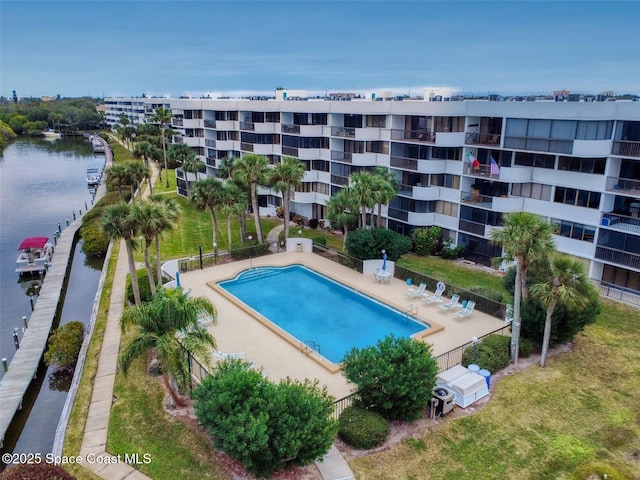 view of swimming pool with a patio, a water view, and a yard