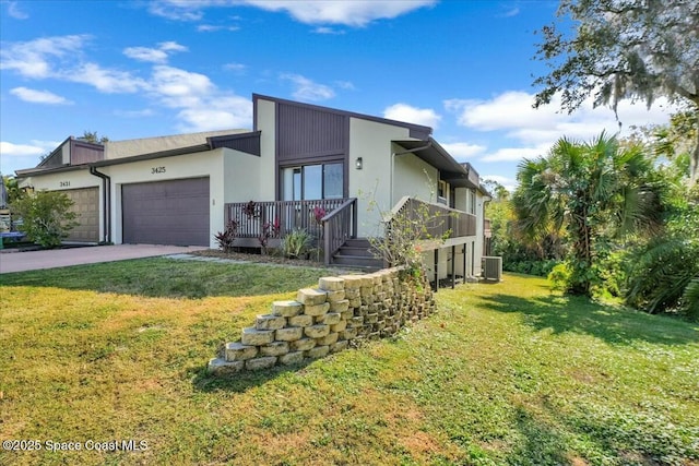 view of front of house featuring central AC, a garage, and a front lawn