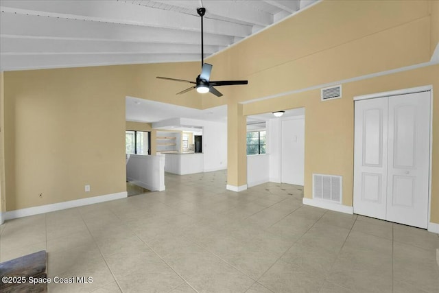 unfurnished living room with ceiling fan, lofted ceiling with beams, and light tile patterned floors