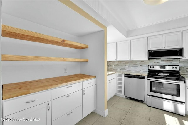 kitchen with white cabinetry, backsplash, light tile patterned flooring, and appliances with stainless steel finishes