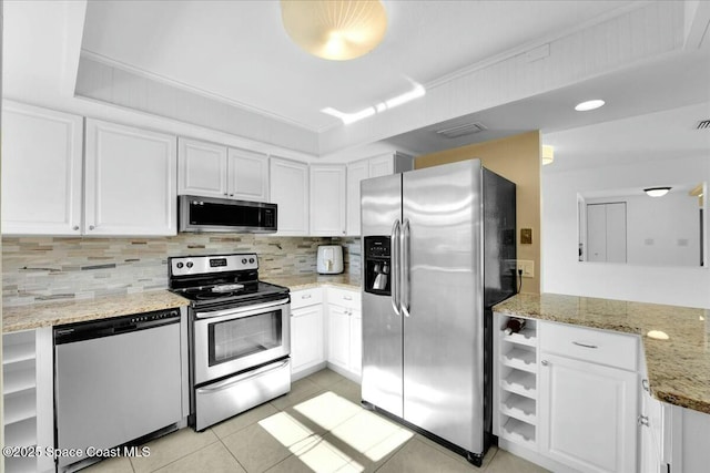 kitchen with white cabinetry, stainless steel appliances, light stone countertops, and decorative backsplash