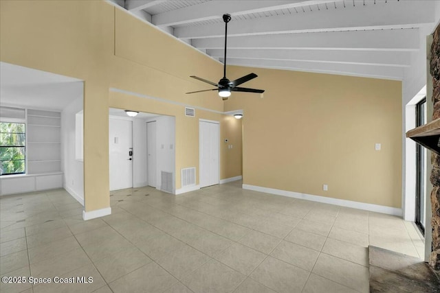 unfurnished living room with light tile patterned floors, built in shelves, lofted ceiling with beams, and ceiling fan