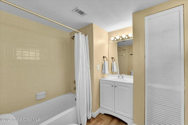 bathroom featuring vanity, wood-type flooring, and shower / bath combo