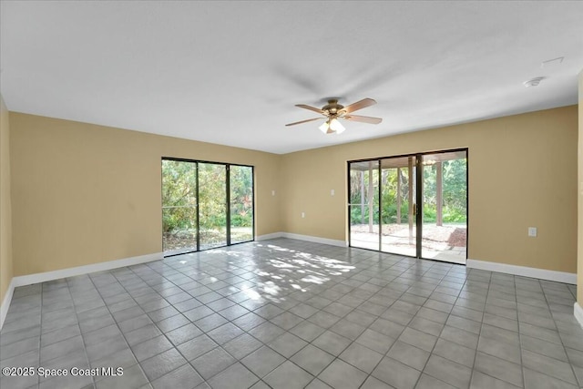 spare room with light tile patterned flooring, a wealth of natural light, and ceiling fan