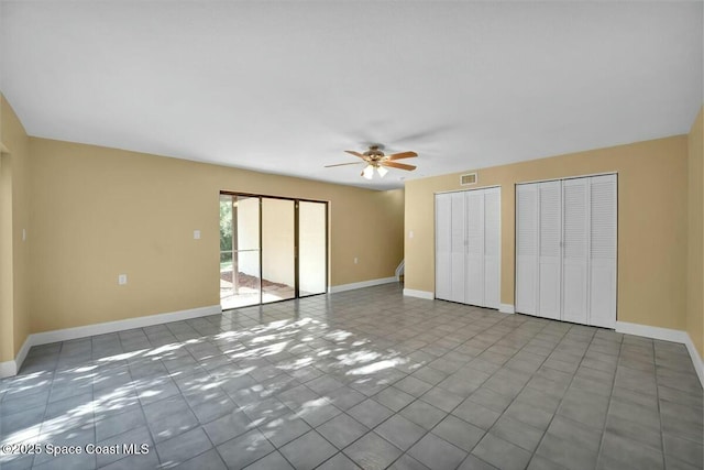 interior space featuring tile patterned flooring, ceiling fan, and multiple closets