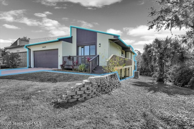 view of front facade with a garage and central AC