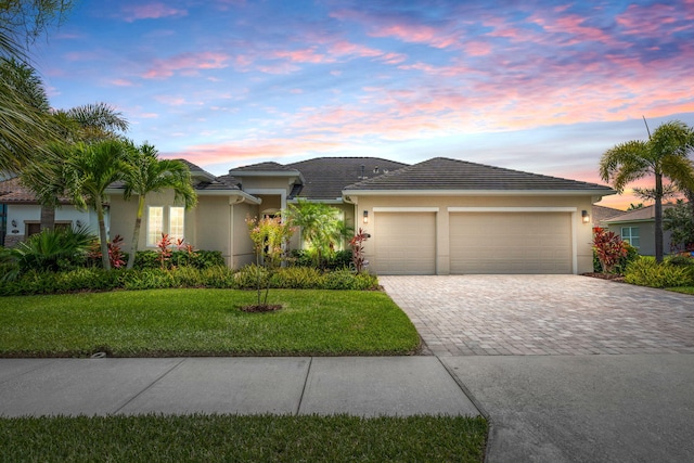 view of front facade with a yard and a garage