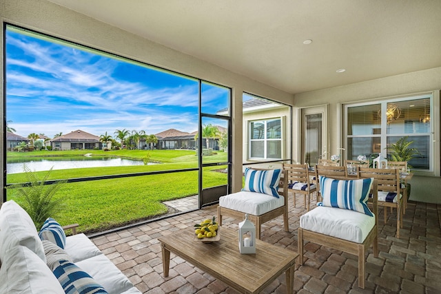 sunroom / solarium featuring a water view