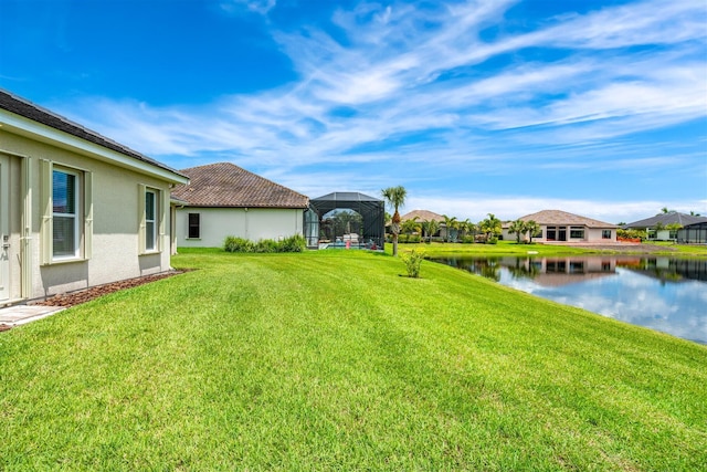 view of yard featuring a water view and glass enclosure